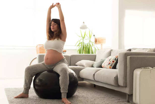 Pregnant woman doing relax exercises with a fitball